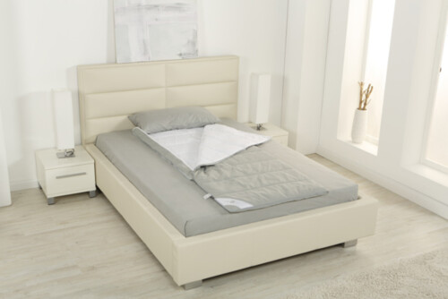 Ein grauer Schlafsack der Serie PULMANOVA von MEDI-TECH auf einem beige-farbigen Bett