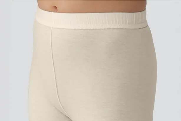 Eine Hose eines beigen Schlafanzugs der Serie PULMANOVA sensitive von MEDI-TECH vor grauem Hintergrund.