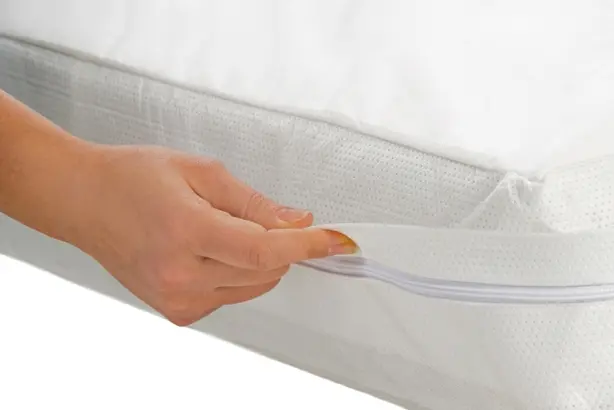 Ein weißer Bezug der Serie PULMANOVA Comfort von MEDI-TECH stellt mithilfe einer Hand die einfache Handhabung des allergendichten Matratzenbezugs dar.